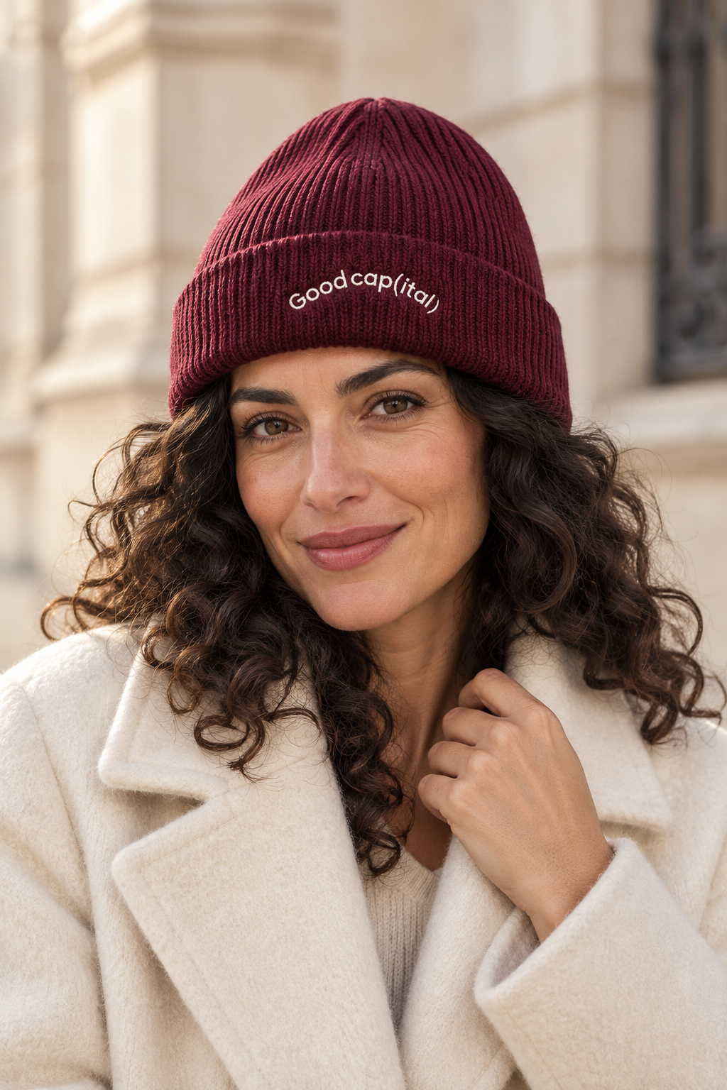 A model wearing the burgundy Good cap(ital) beanie with cream embroidery